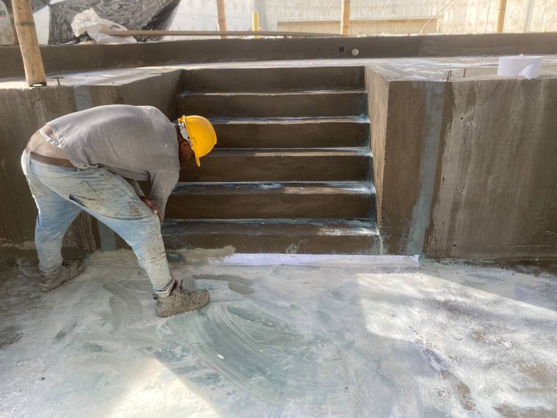 Operario aplicando el producto impermeabilizante en el vaso de la piscina